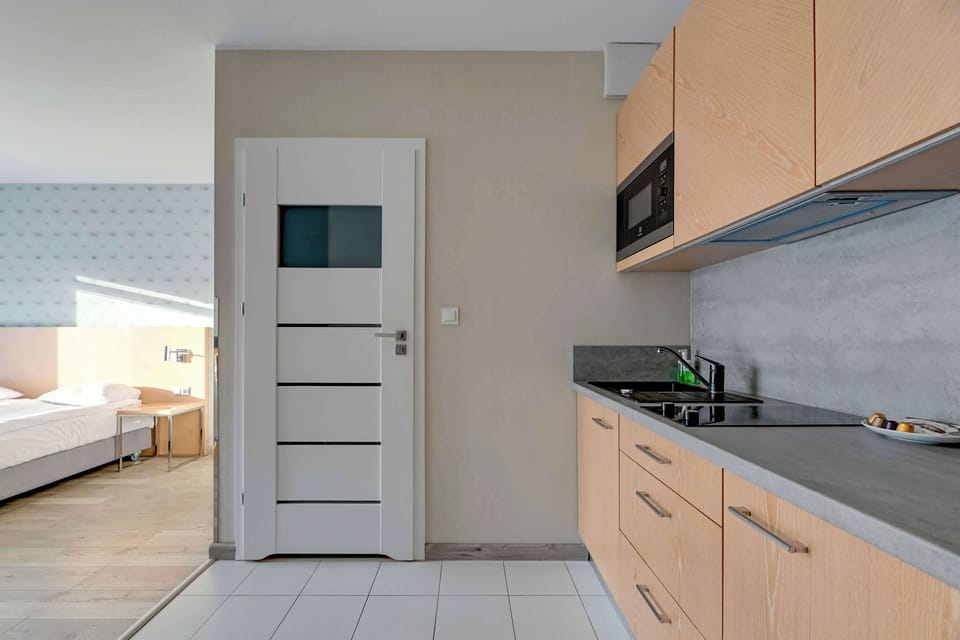 Another angle of the kitchenette, emphasizing its compact size and functional design. Wooden cabinetry and a sleek countertop make the space practical for small meals.