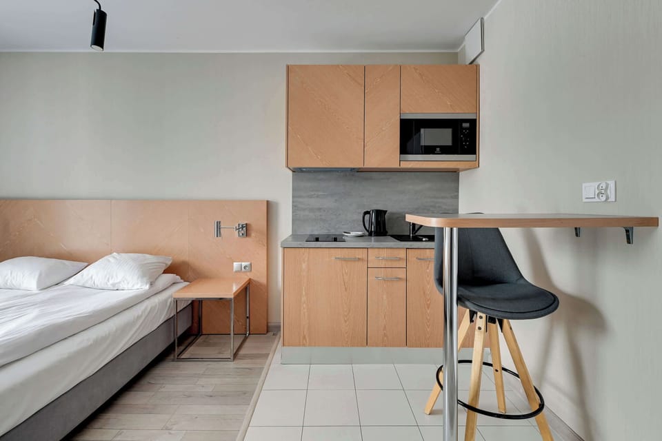 Dining area with a small round table and one chair The table is placed near a beige wall and a hanging light, making the area stylish and inviting.