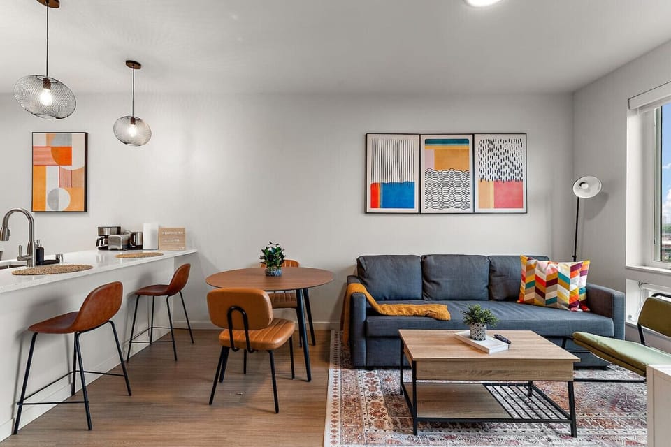 This inviting open-concept space blends mid-century charm with vibrant art for a lifestyle.