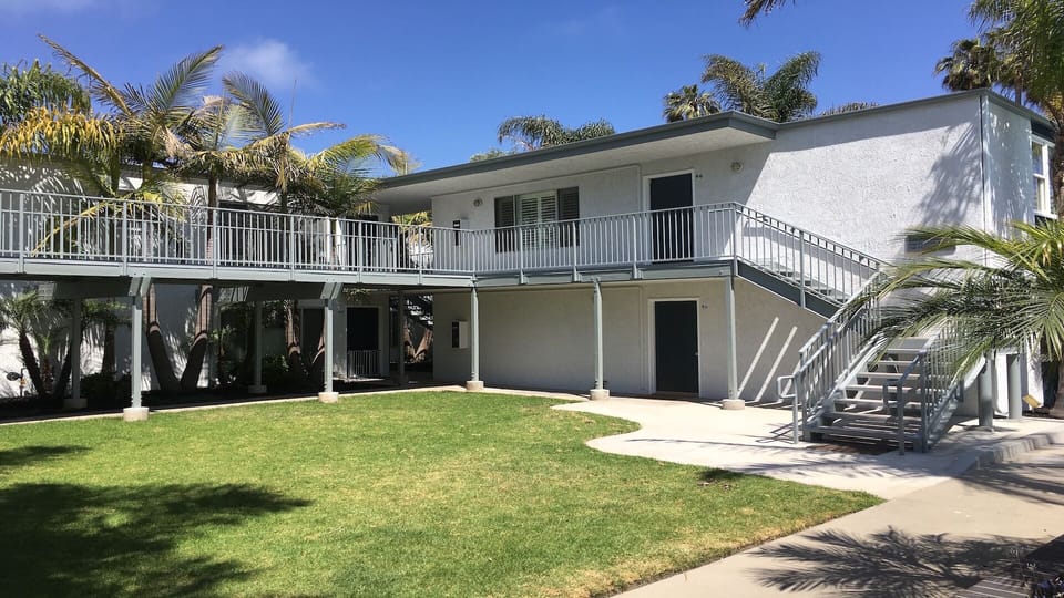 Grass courtyard with stairs up to this unit