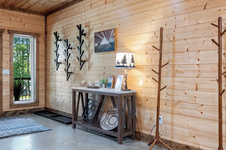 A cozy welcome awaits—this wood-paneled entryway sets the tone with forest-themed decor, natural textures, and thoughtful touches from the moment you arrive.