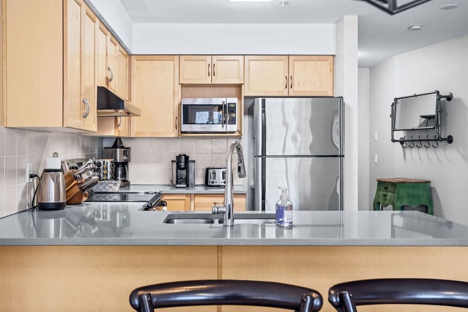 Fully equipped kitchen featuring a breakfast bar with seating for two, perfect for casual meals and morning coffee.