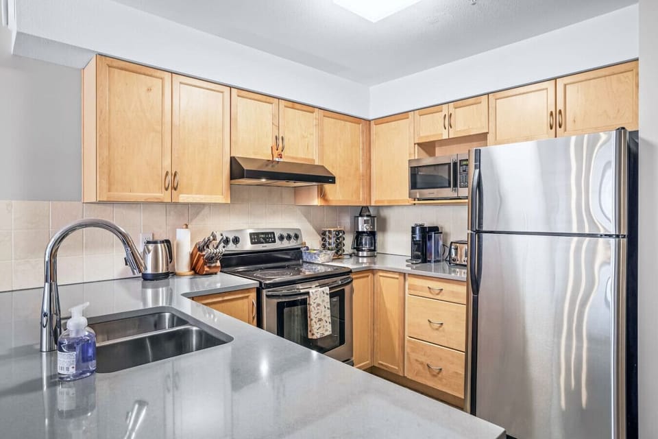 Fully equipped kitchen featuring a breakfast bar with seating for two, perfect for casual meals and morning coffee.