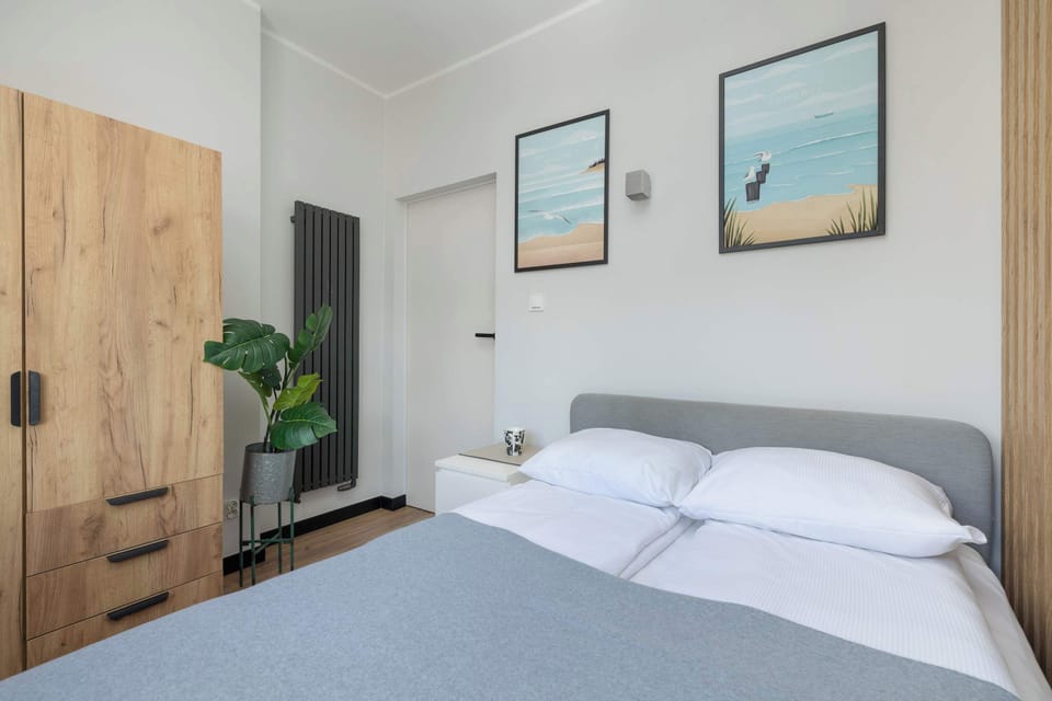 Another angle of the bedroom, showcasing a wardrobe and a cozy sleeping area. The soft color palette enhances relaxation.
