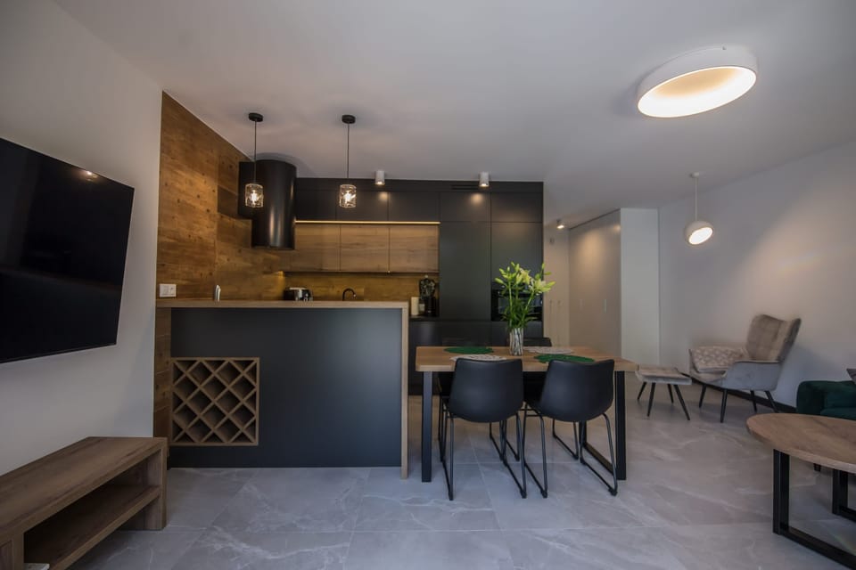 Kitchen and dining area with bar-style seating and modern appliances.