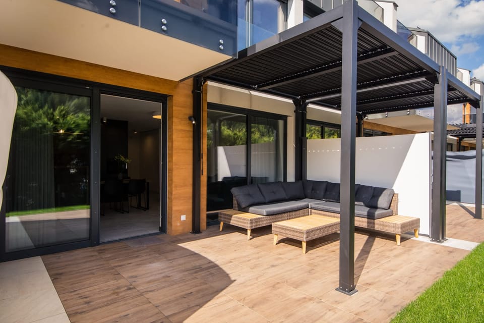 Exterior view of a modern apartment with terrace and outdoor seating.