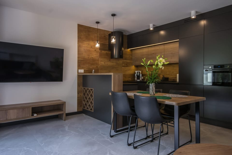 Dining area with dark wooden table, chairs, and fresh flowers.