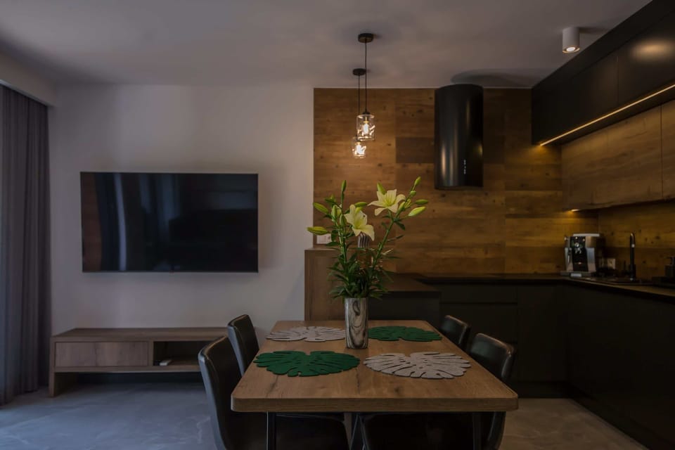 Living room with wall-mounted TV, sofa, and coffee table.