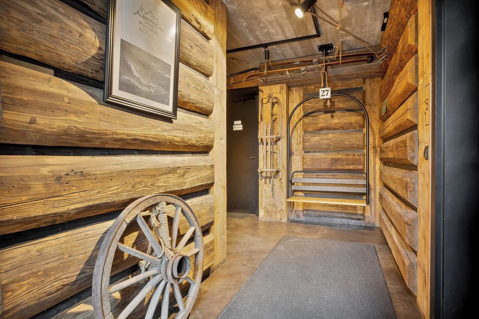 An exterior entrance to a building with a rustic wooden finish and wagon wheel decor on the wall.

