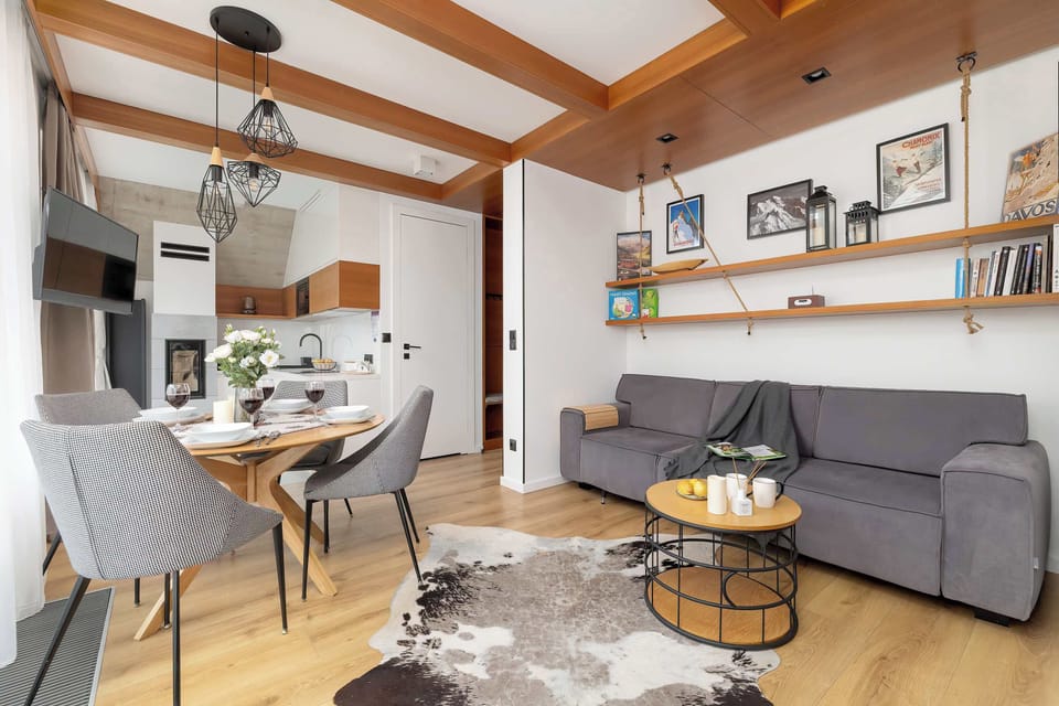 A different angle of the same room highlighting the contemporary light fixtures, decorative accents, and comfortable seating.