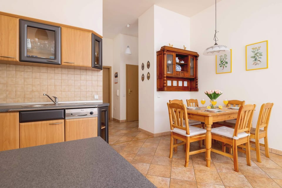 Fully equipped kitchenette with electric cooktop, oven, microwave, refrigerator with freezer, dishwasher, electric kettle, coffee maker and dining area.