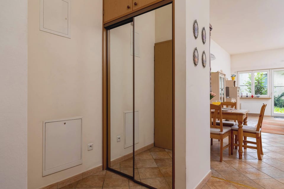 Hallway with a closet with mirror.