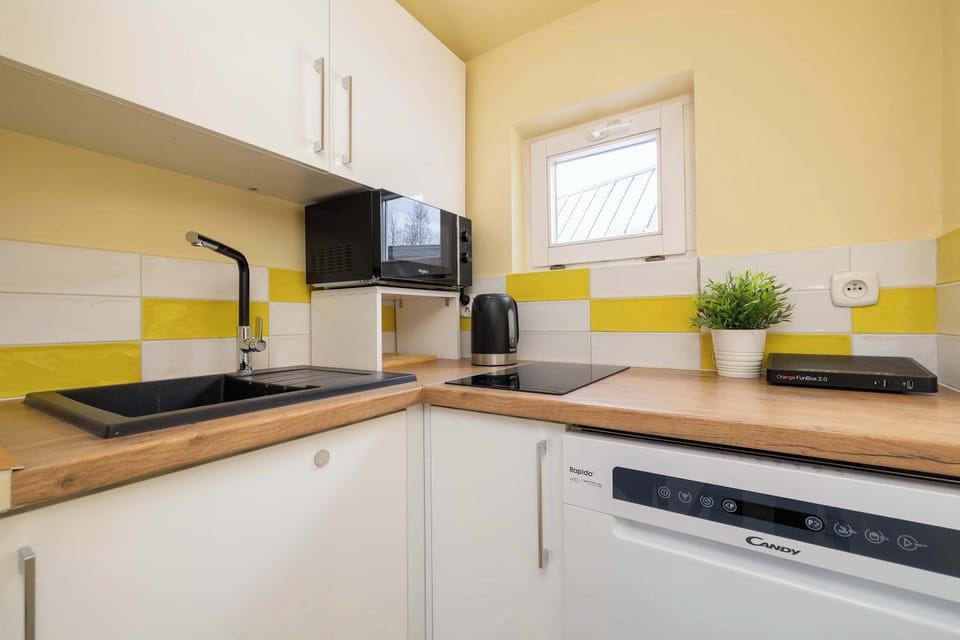 A functional kitchen with light-coloured furniture and a wooden worktop ensures that home-cooked meals can be prepared.