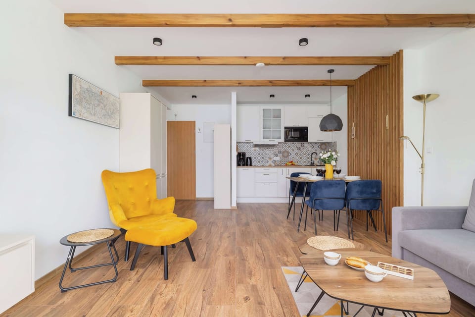 A modern interior with a yellow chair, wooden feature wall, and a clean aesthetic.

