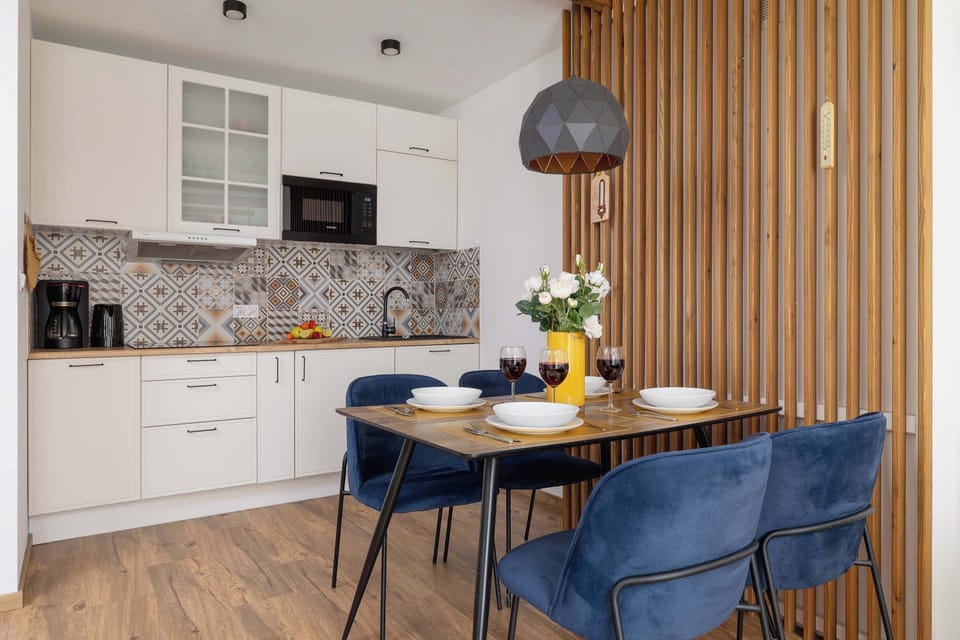 A cozy dining space next to the kitchen, with a small round table and elegant pendant lighting.

