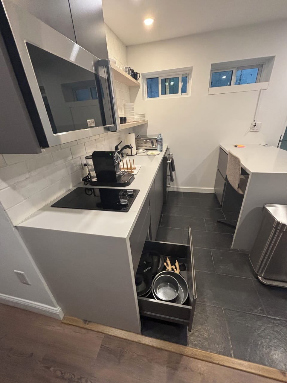 Kitchen with all the essentials, including microwave, cooktop, and refrigerator 