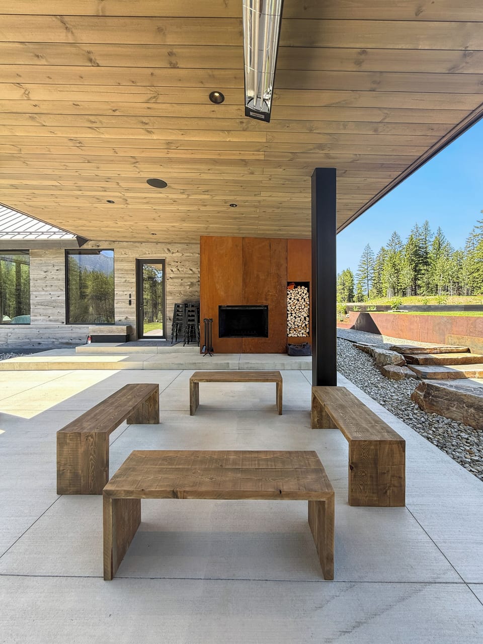 Spacious outdoor area with ample seating, a fireplace, and fire pit  perfect for gathering.