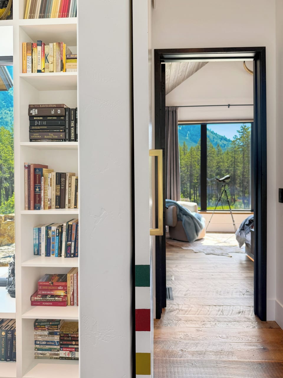Colorful hallway with custom sliding doors and warm wood floors, leading to a cozy bonus area near the main bedroom.