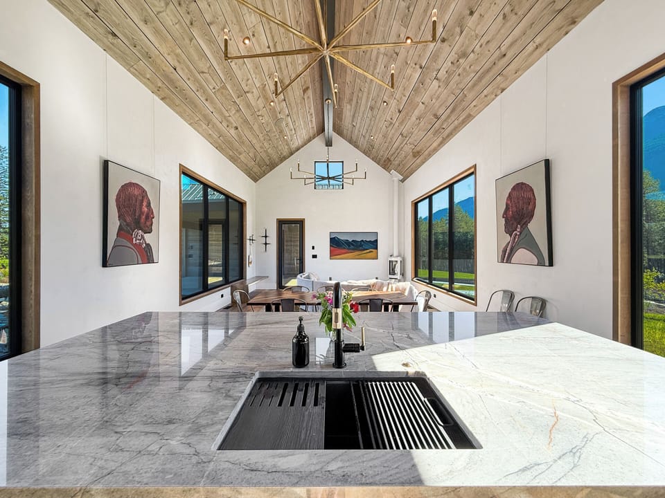 Bright, open kitchen and dining space with mountain views, vaulted ceilings, and ample seating for group gatherings.