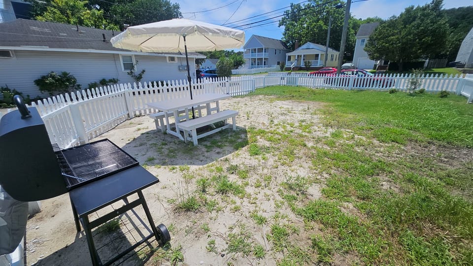 Front Yard has a BBQ grill, large table with seating and umbrella for shade and is fully fenced for kids and pets