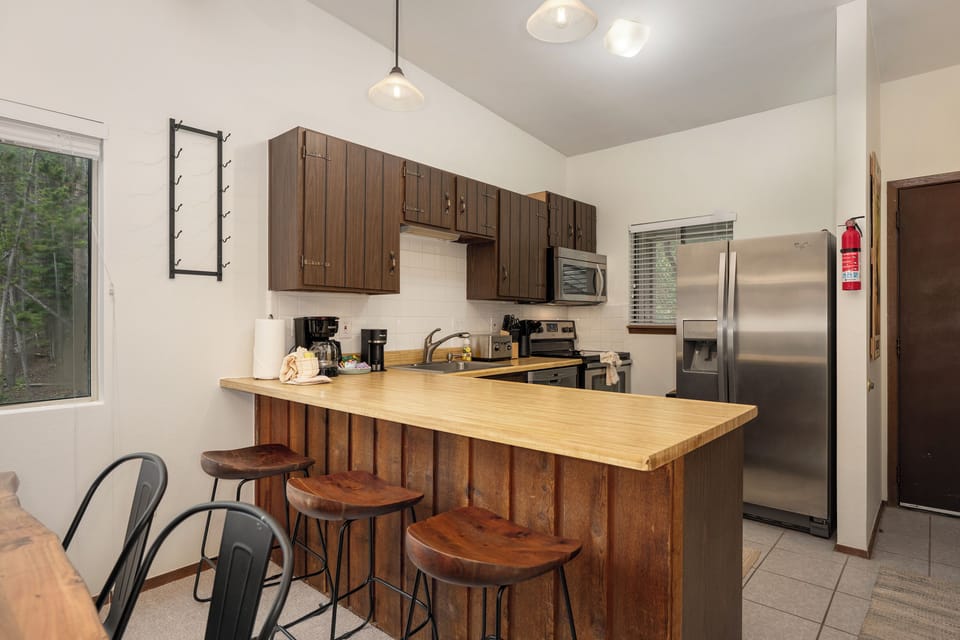 Your fully equipped kitchen features warm wood cabinetry, stainless steel appliances, and a breakfast bar where you'll enjoy morning coffee.