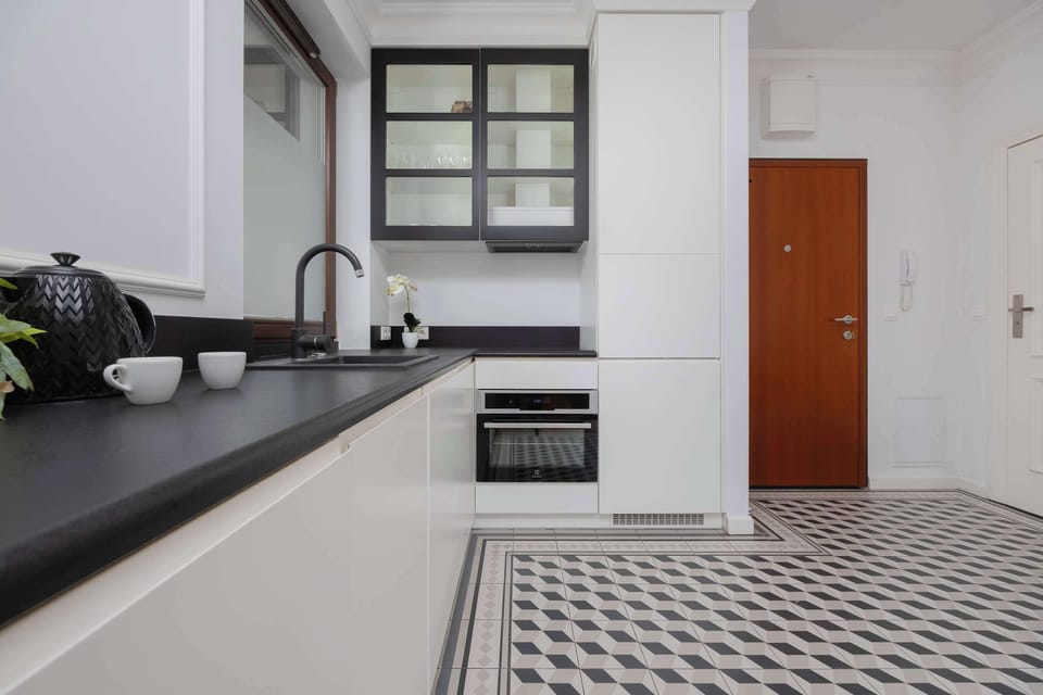 A close-up of the black sink and cabinetry near a window, emphasizing sleek, minimalist design.