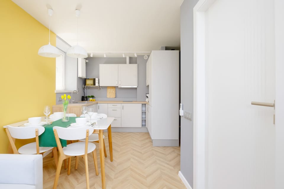 Cozy kitchen and dining area with modern furniture and pendant lighting.