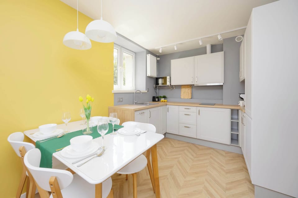 Cozy kitchen and dining area with modern furniture and pendant lighting.