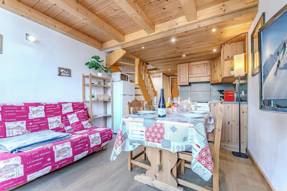 Cozy lounge area with a pull-out sofa bed and TV, perfect for relaxing evenings after skiing.