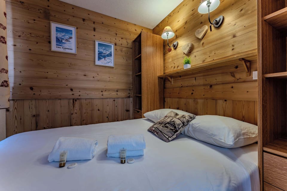 🛌 Rest in alpine comfort. A peaceful bedroom with a double bed, wood accents, charming décor, and soft lighting – your personal haven after an active day outdoors.