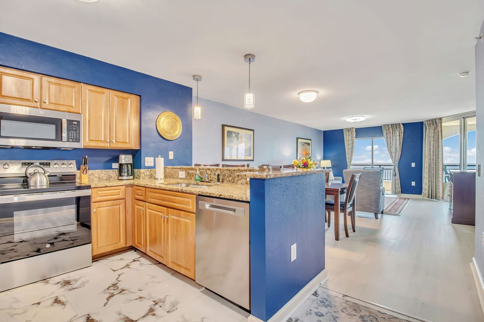 Your fully equipped kitchen opens to dining and living areas, creating perfect space for preparing meals and entertaining with stunning views.