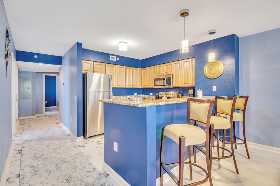 Enjoy preparing meals in your modern kitchen with granite counters, stainless appliances, and stylish breakfast bar seating.