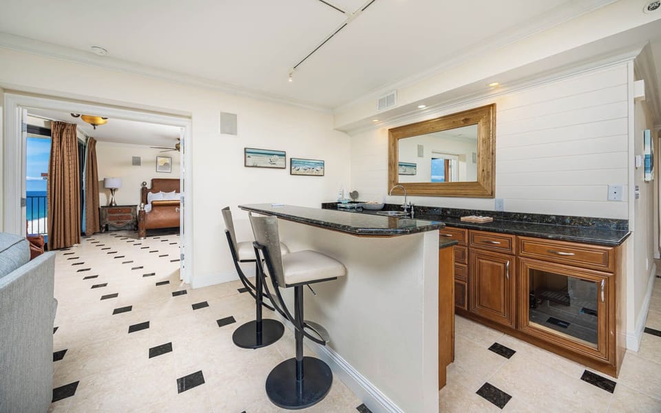 Gather at this elegant wet bar and have a cocktail or glass of wine, featuring a stereo and wine cooler
