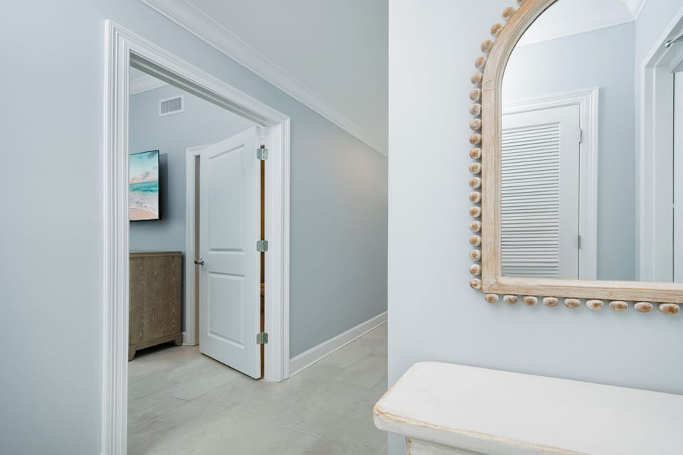 Step into this welcoming hallway featuring a decorative mirror and soft colors
