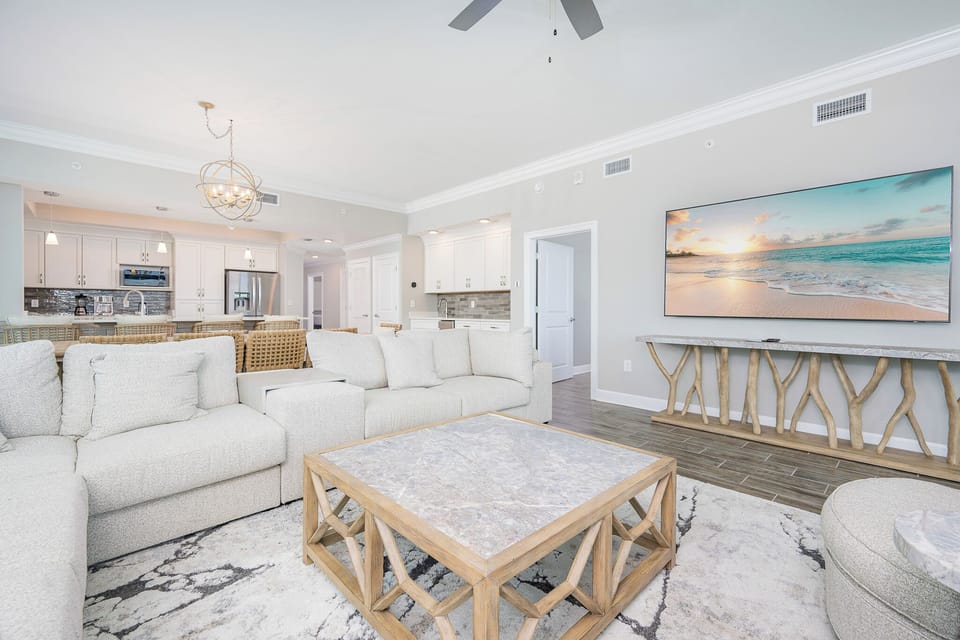 Relax in the spacious living area with plush seating, a stylish coffee table, and a large TV