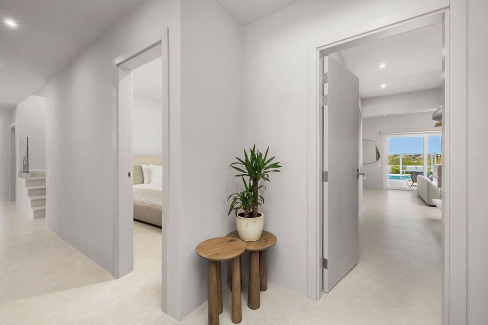 Spacious hallway with access to multiple suites, filled with natural light and thoughtful touches—offering privacy, flow, and a seamless indoor-outdoor feel.