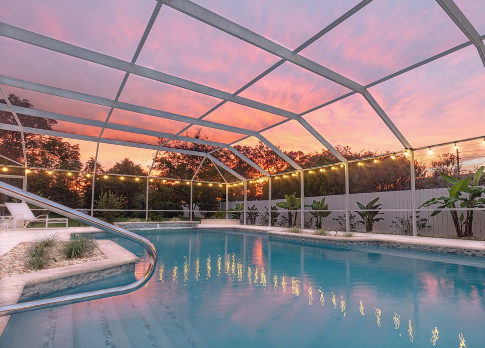 Unwind in the screened-in pool as sunset colors glow overhead & string lights set the mood for peaceful evening swims.