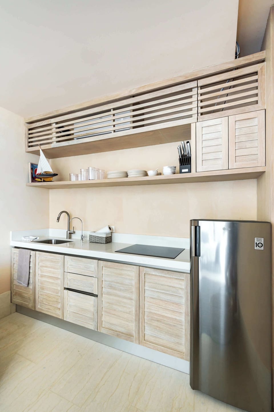 Cocina completa con refrigerador, parilla de inducción y elementos básicos de cocina 