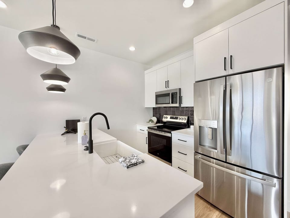 Modern fully stocked kitchen with stainless steel appliances, spacious island & stylish fixtures — perfect for cooking & gathering in