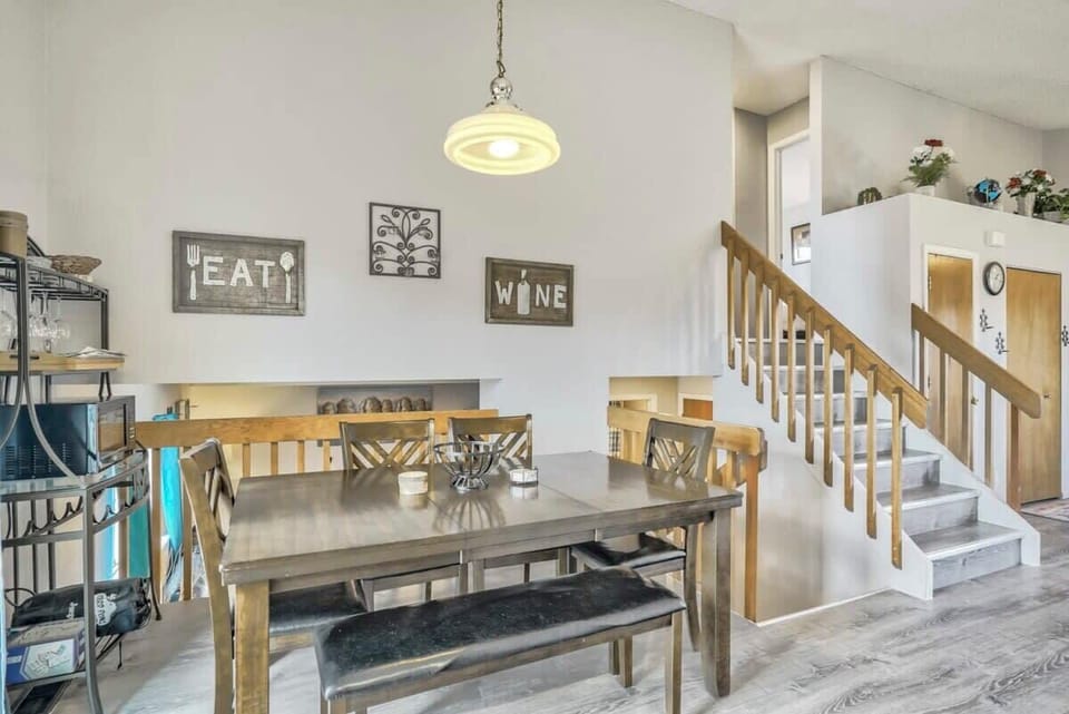 Spacious dining area with seating for six and direct access to the backyard deck. A half wall overlooks the lower lounge, adding a sense of openness while still giving everyone their own space.