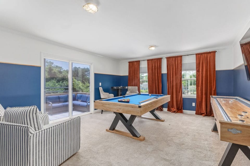 Game room featuring a pool table, shuffleboard table, comfortable seating and a 60 inch tv