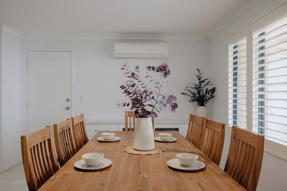 Gather around this beautifully set wooden dining table for eight, complete with stylish decor and air conditioning for year-round comfort.