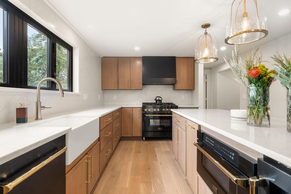 Warm cabinetry, brass hardware, and a pro range. Cooking here feels like a treat.