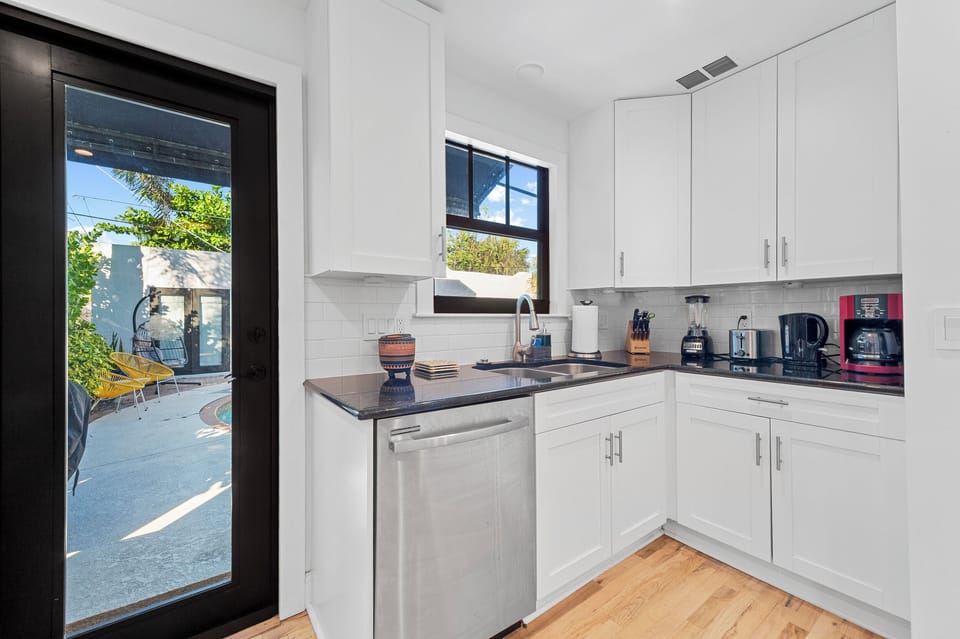 Kitchen: Bright white cabinets complement sleek appliances and a sunny view of your private patio!