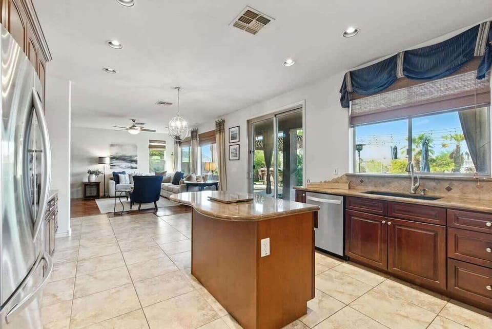 The fully equipped modern kitchen is stocked with all culinary essentials, stainless-steel appliances, a kitchen island, and private access to the backyard ranch retreat. (1st Floor)