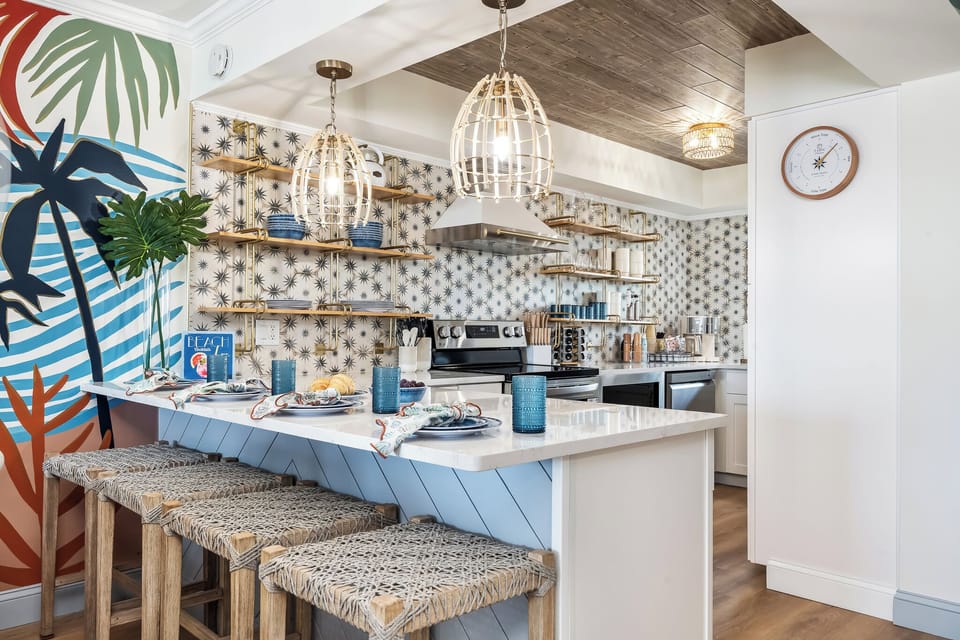 our coastal-chic kitchen is fully loaded with modern appliances, open shelving, and woven bar stools.