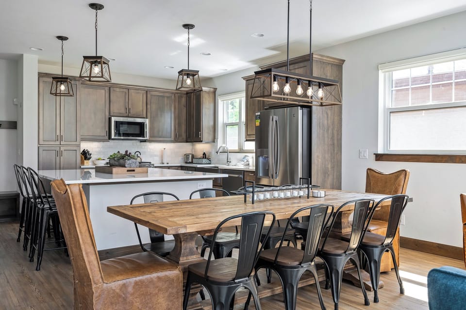 - Farmhouse style dining table seats eight under warm pendant lighting - Fully equipped kitchen with stainless steel appliances and modern layout - Perfect for hosting big breakfasts or post-hike dinners with family