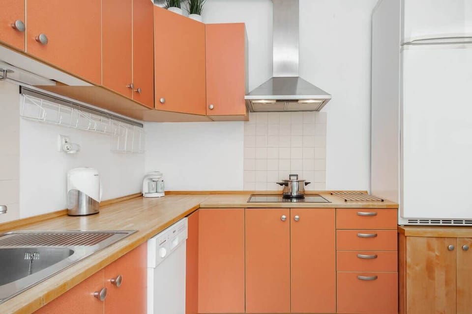 A kitchen with bright orange cabinets, offering a functional and colorful cooking area.
