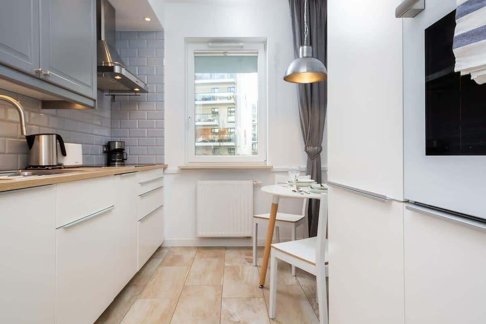 Kitchenette with kettle and refrigerator. 