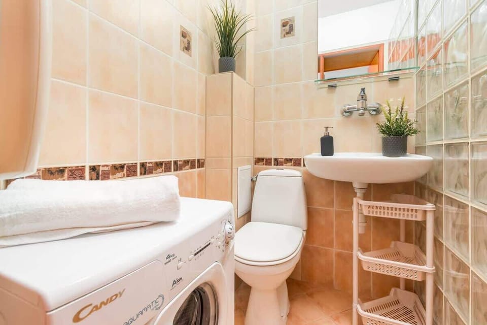 Bright bathroom with washing machine and shower cabin. 